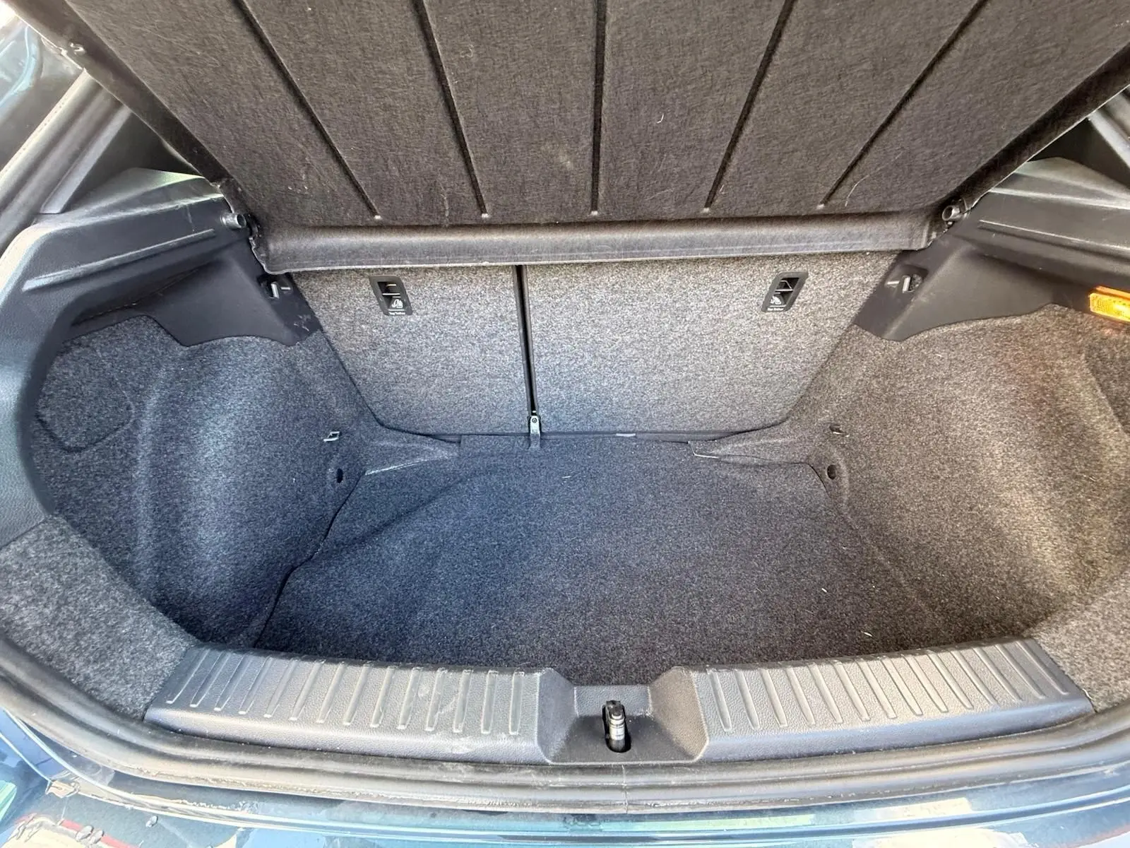 Coffre ouvert de la SEAT Ibiza 1.0 TSI 95 FR gris foncé, vue intérieure montrant l'espace de rangement vide.