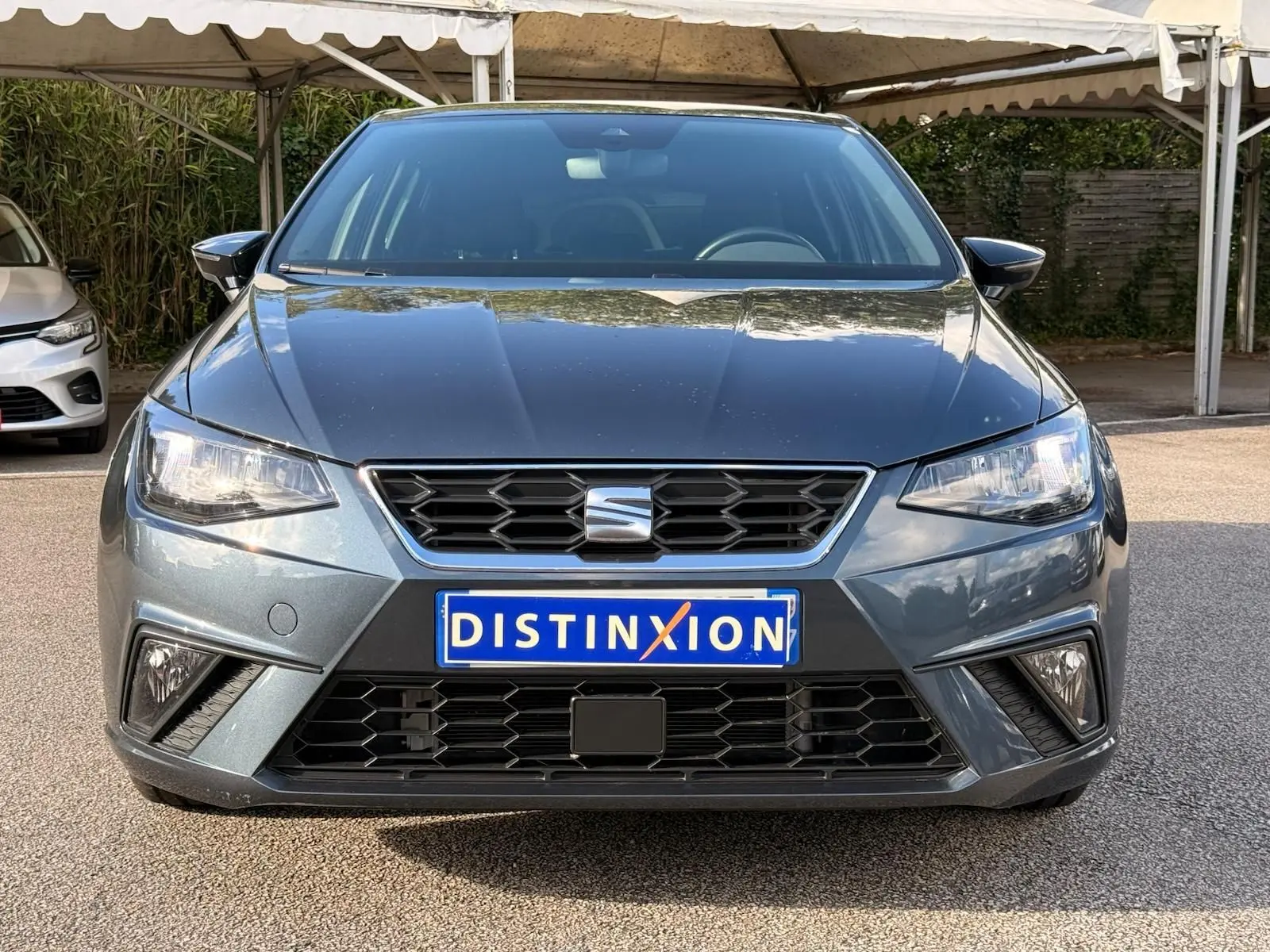 Vue frontale d'une SEAT Ibiza 1.0 TSI 95 FR gris foncé avec calandre noire et phares LED allumés.