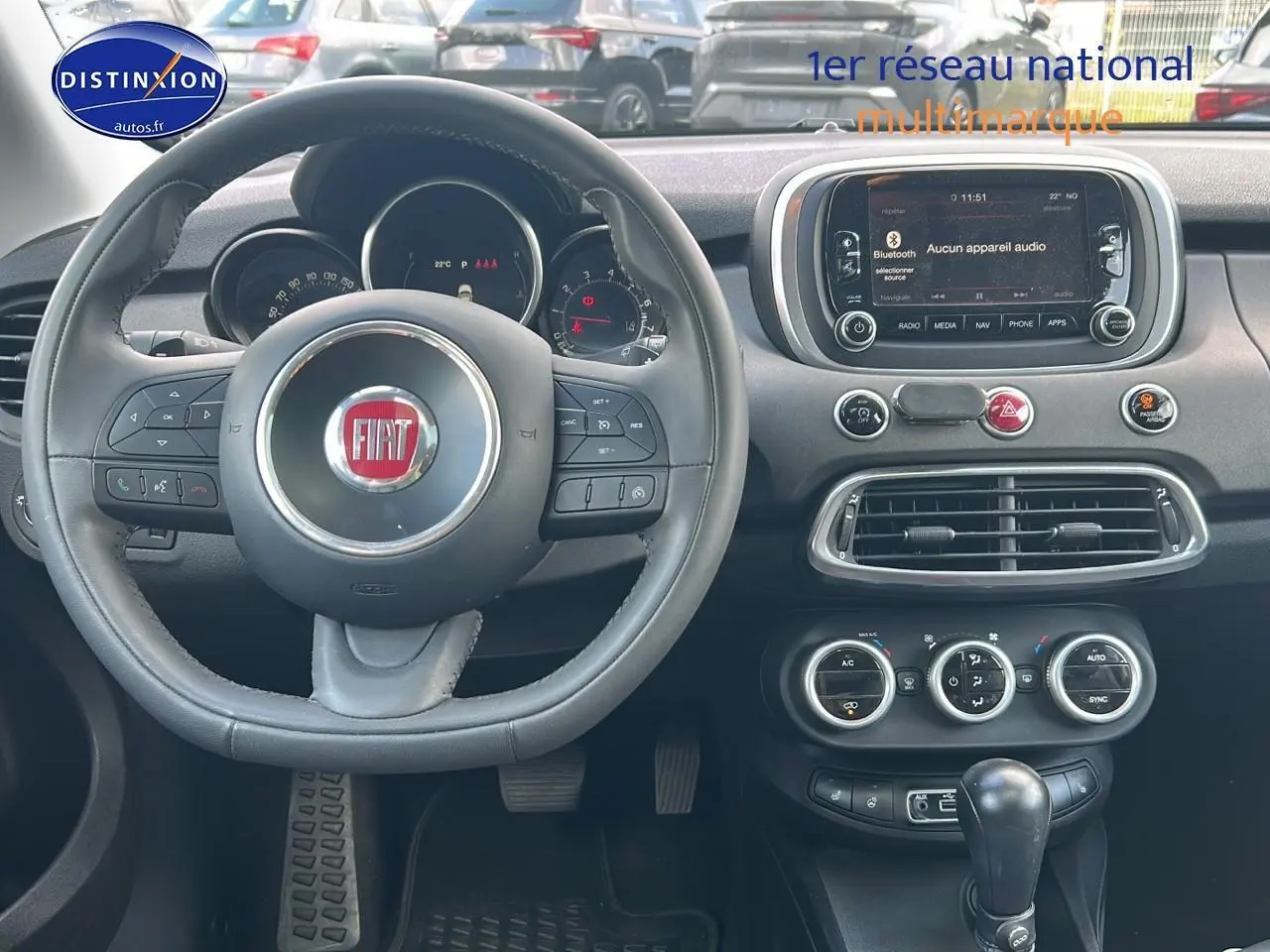 Vue centrée sur le volant cuir multifonction et tableau de bord du Fiat 500X 1.4 rouge de 2016.