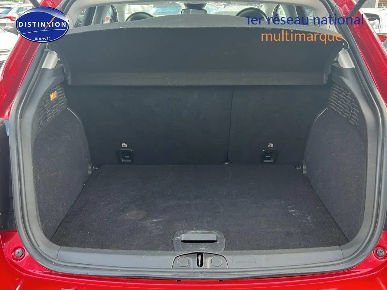 Coffre ouvert d'une FIAT 500X rouge, vue arrière mettant en valeur l'espace de chargement et la tablette cache-bagages.