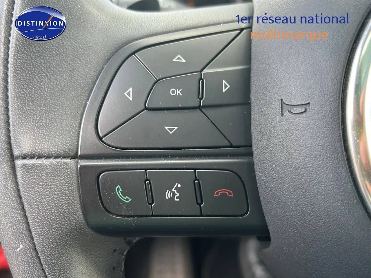 Gros plan sur les commandes au volant cuir multifonction de la FIAT 500X rouge, version 2016 cross.