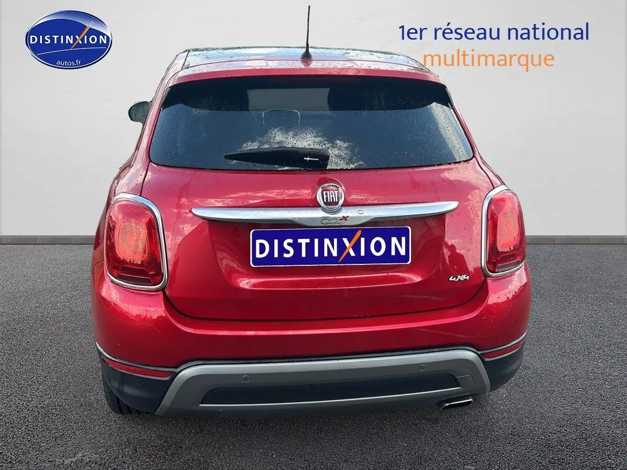 Vue arrière d'un FIAT 500X rouge 2016 avec hayon teinté et sortie d'échappement chromée visible côté droit.