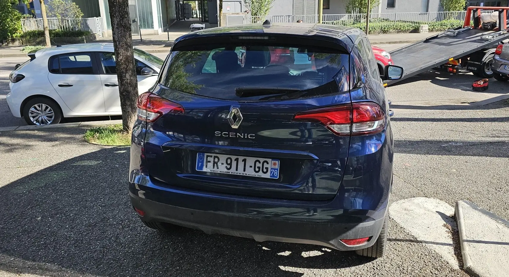 Vue arrière d'un Renault Scénic bleu cosmos métal de 2020, avec feux arrière allongés et plaque d'immatriculation française.