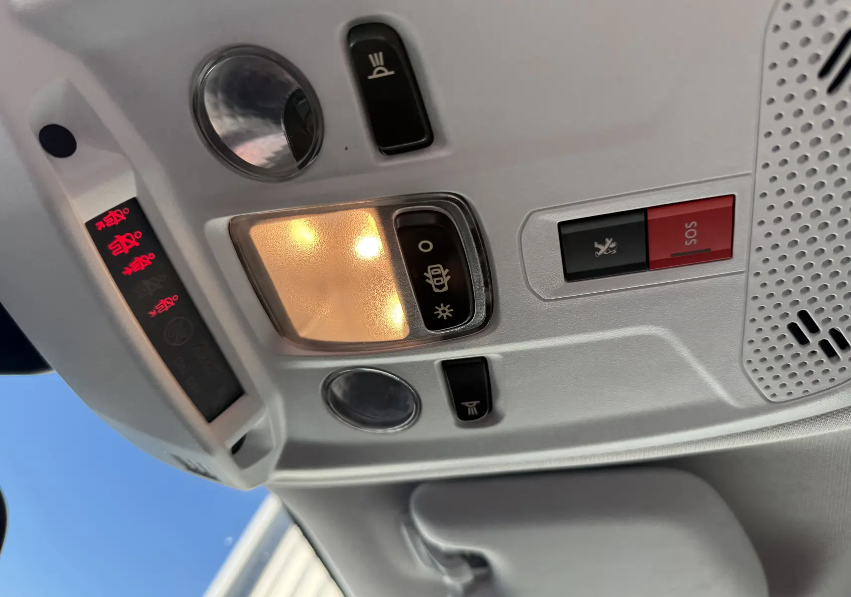 Plafonnier intérieur allumé avec boutons SOS et éclairage, dans un Peugeot 2008 gris diesel 2020, vue vers le toit
