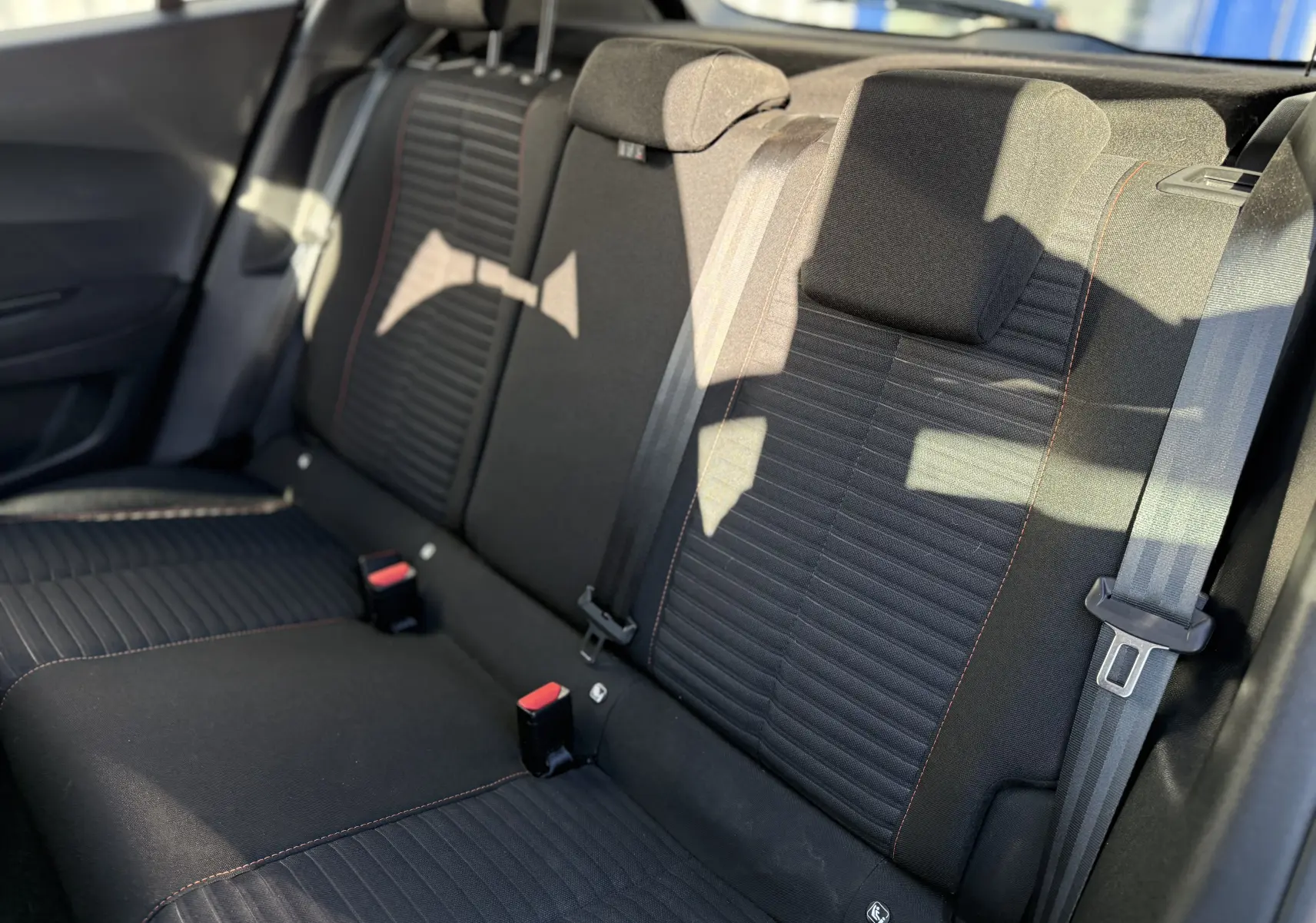 Vue rapprochée des sièges arrière en tissu noir avec surpiqûres orange du Peugeot 2008 gris 1.5 HDI Active 2020.