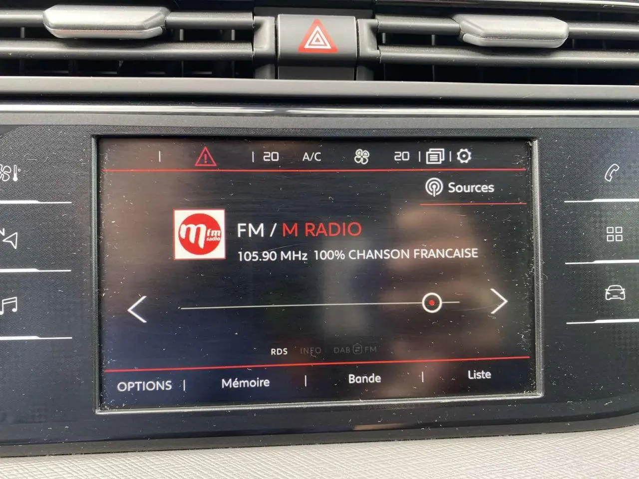 Écran tactile central du Citroën C4 Spacetourer 2019 affichant la radio FM avec interface noire et touches tactiles latérales.