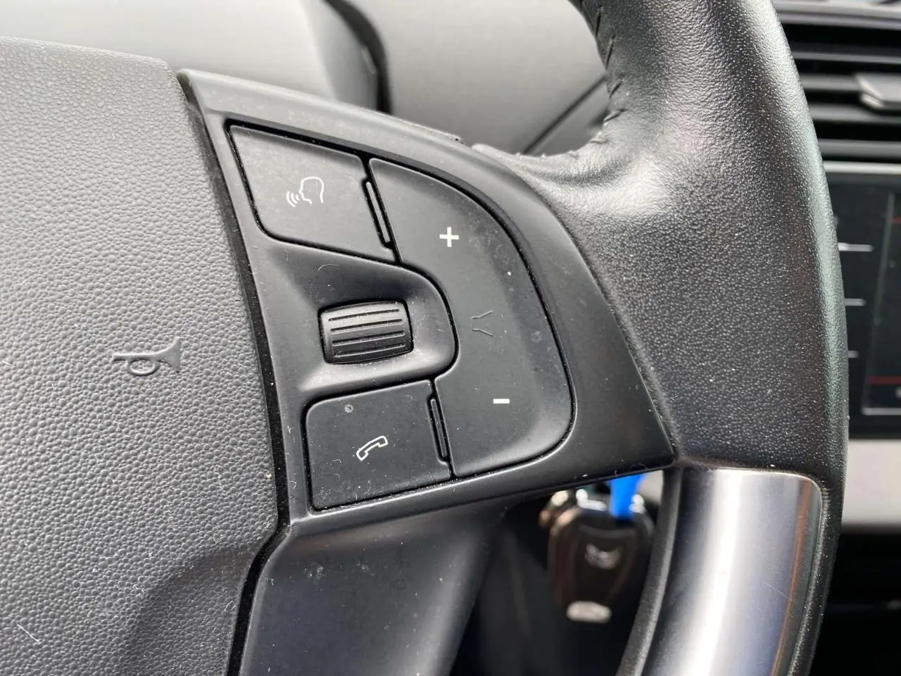 Gros plan sur les commandes du volant noir du Citroën C4 Spacetourer 2019, version diesel manuelle.