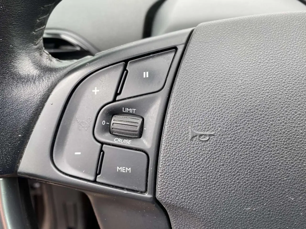 Gros plan sur les commandes de régulateur de vitesse au volant noir du Citroën C4 Spacetourer 2019.