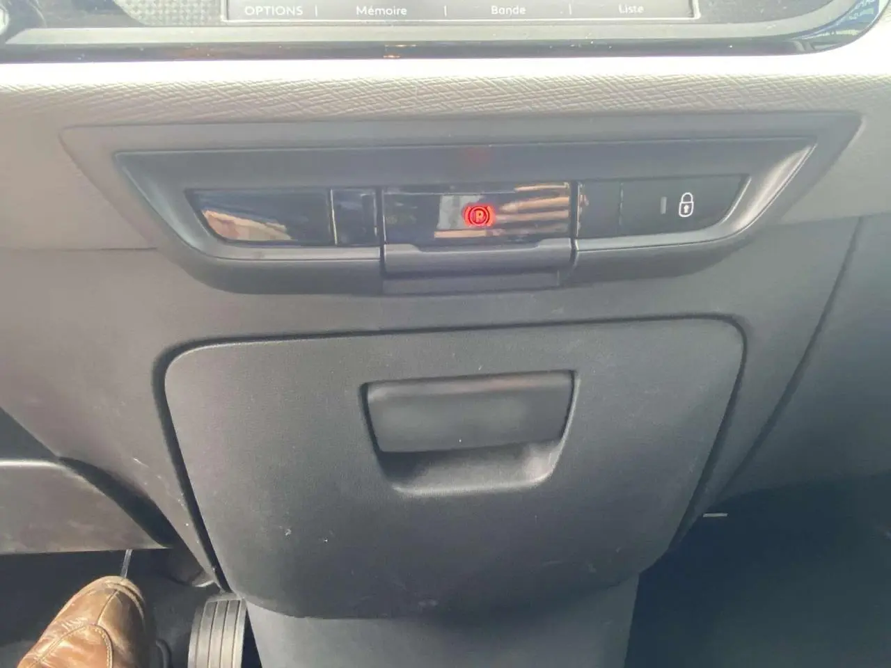 Vue rapprochée de la console centrale noire du Citroën C4 Spacetourer 2019 avec bouton de frein à main électronique allumé.