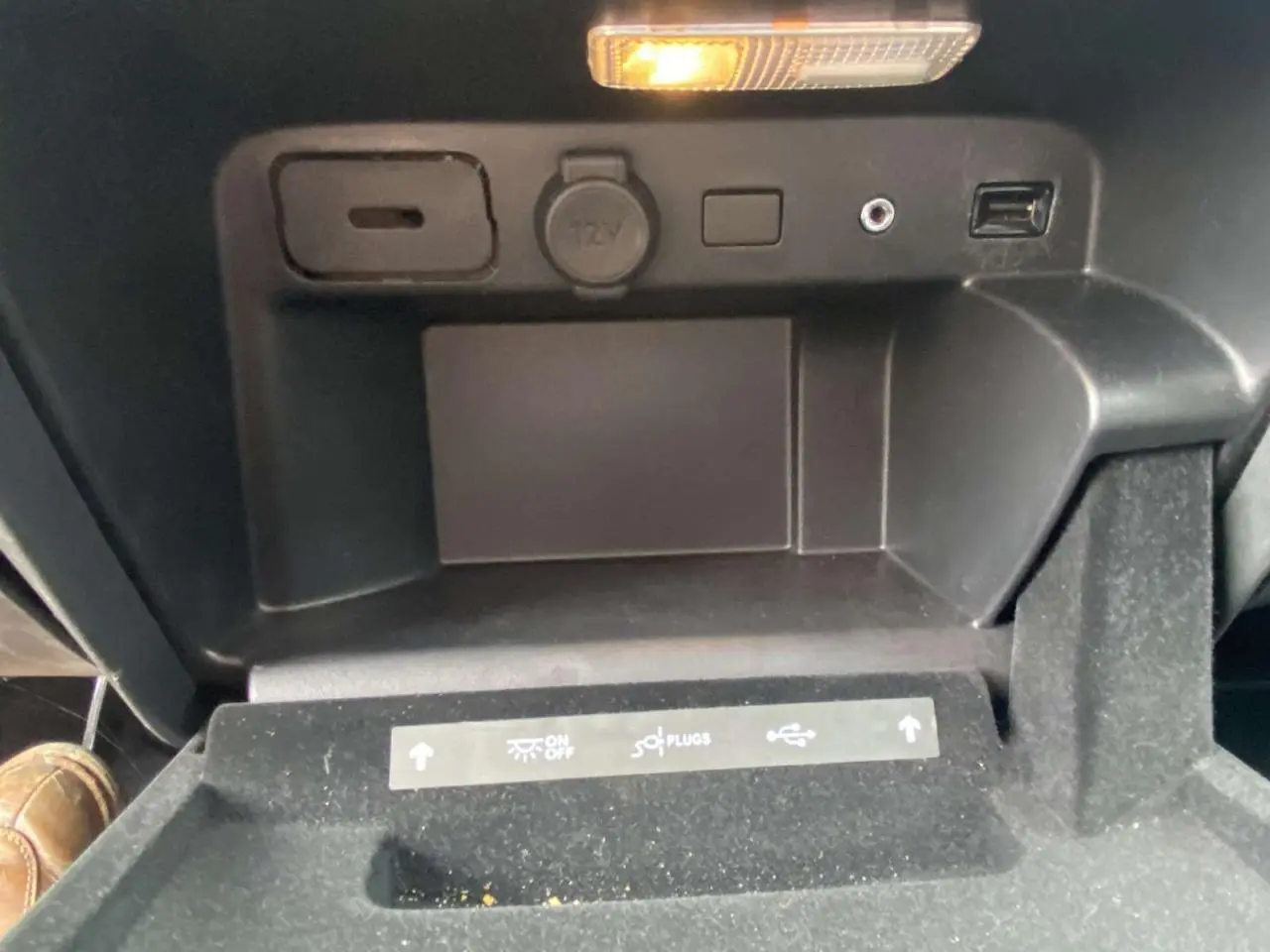 Gros plan sur la console centrale noire du Citroën C4 Spacetourer 2019, montrant prises et éclairage intérieur.