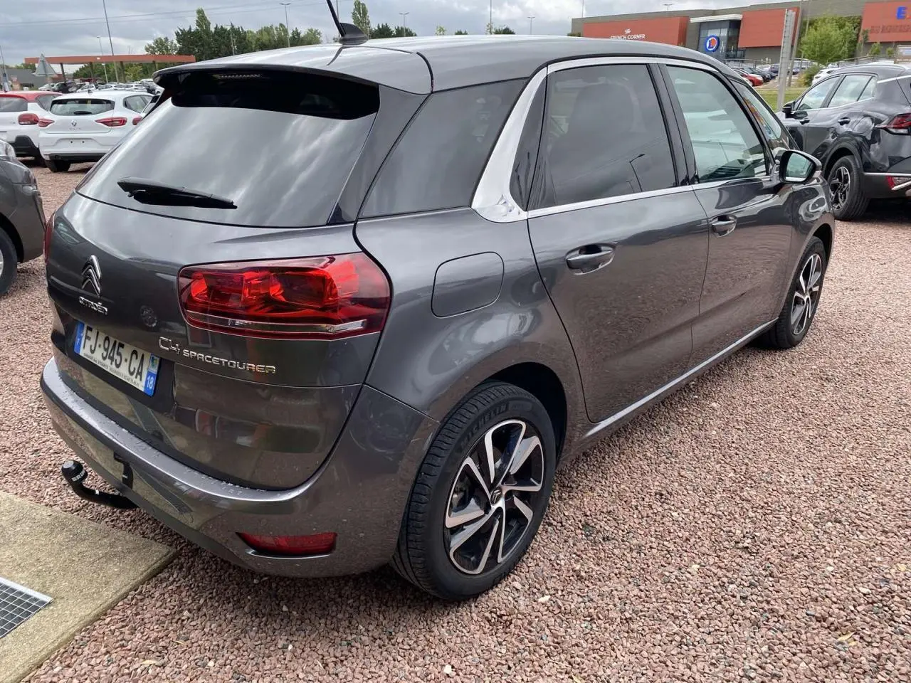 Vue 3/4 arrière droite d'une Citroën C4 Spacetourer gris métallisé avec jantes alliage et attelage visible.