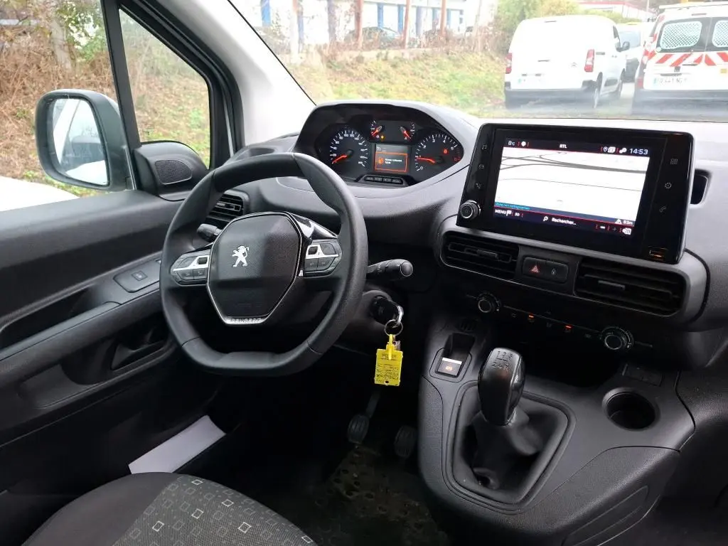 Vue intérieure côté conducteur du Peugeot Partner 2020, tableau de bord avec écran tactile et levier de vitesse manuel.