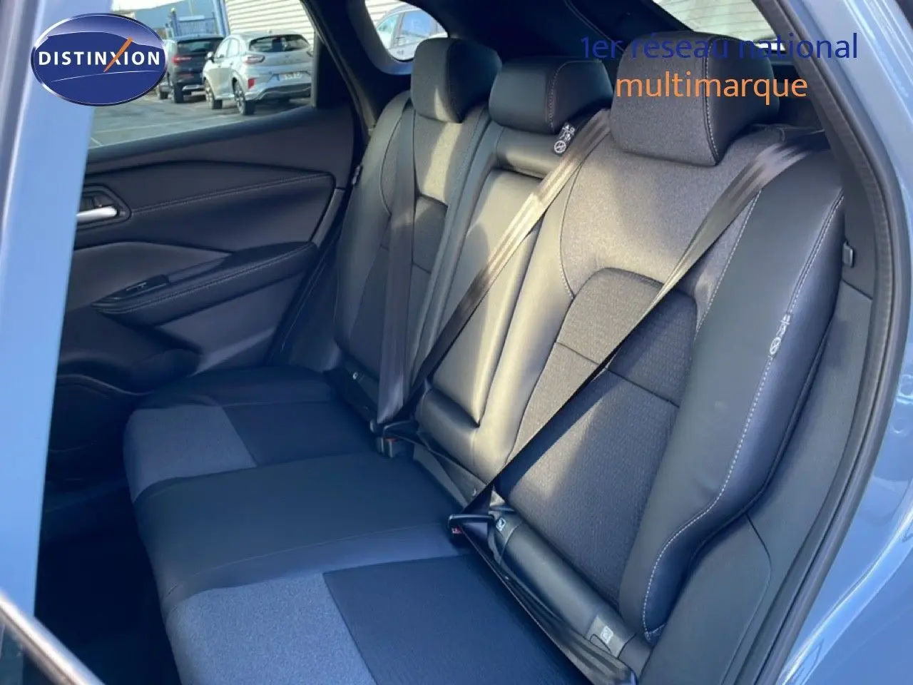 Vue intérieure des sièges arrière en cuir noir et tissu gris du Nissan Qashqai 2025, porte arrière ouverte côté droit.