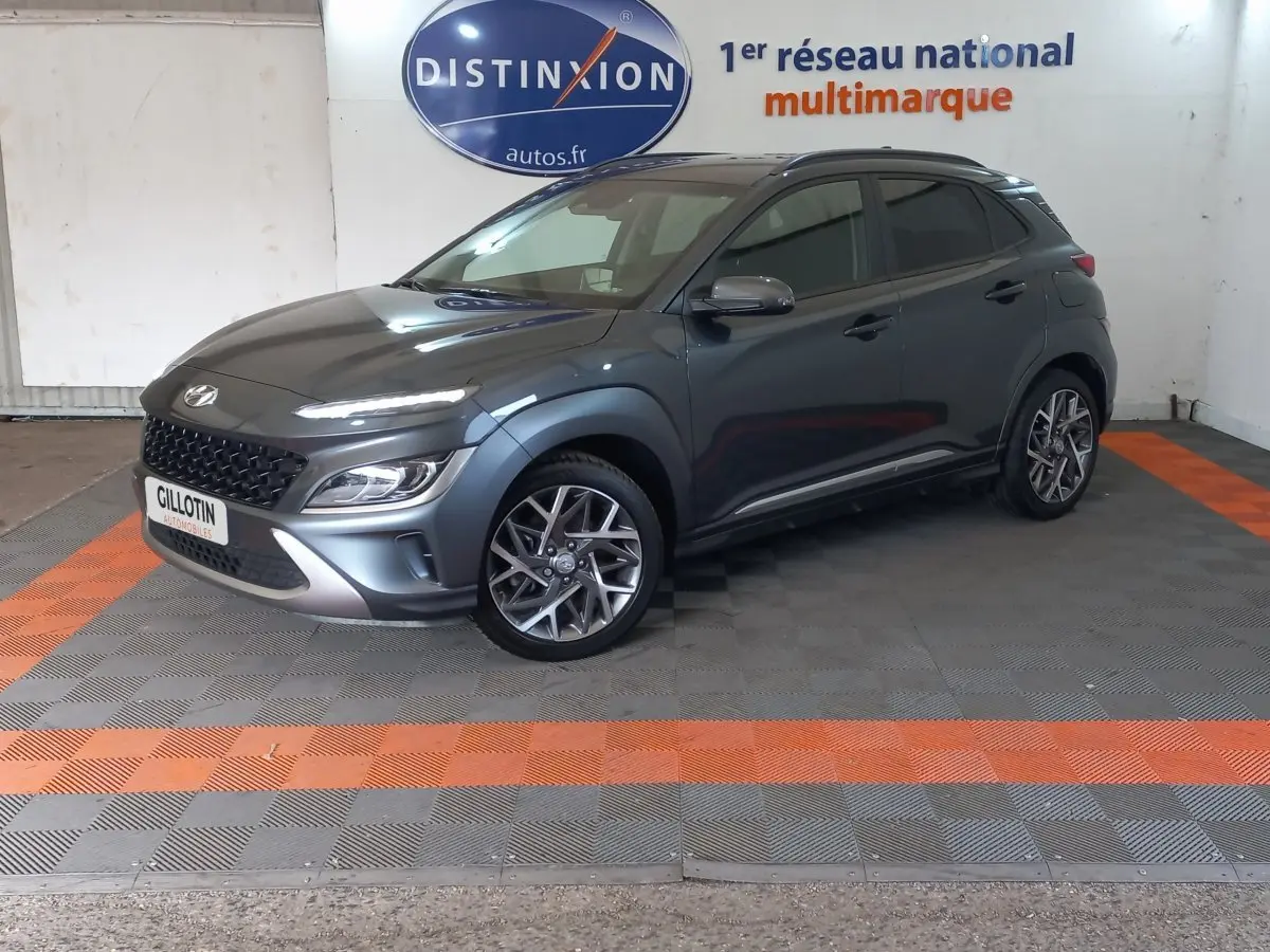 Hyundai Kona 1.6 Hybrid gris foncé en 3/4 avant droit, avec jantes alliage et toit noir contrasté.