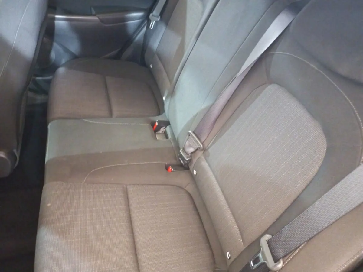 Vue intérieure sur la banquette arrière grise du Hyundai Kona 1.6 Hybrid 2022 avec ceintures de sécurité visibles.