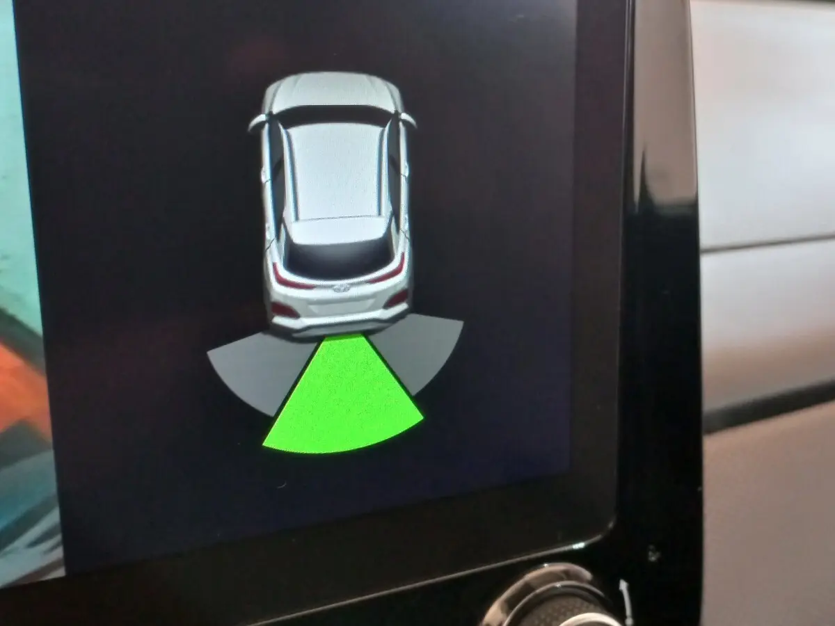 Affichage écran tactile montrant l'aide au stationnement arrière du Hyundai Kona gris foncé 2022 en vue de dessus.