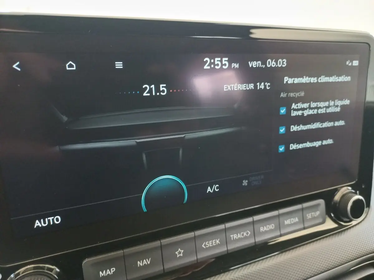 Écran tactile central du tableau de bord du Hyundai Kona gris foncé, affichant les paramètres de climatisation.