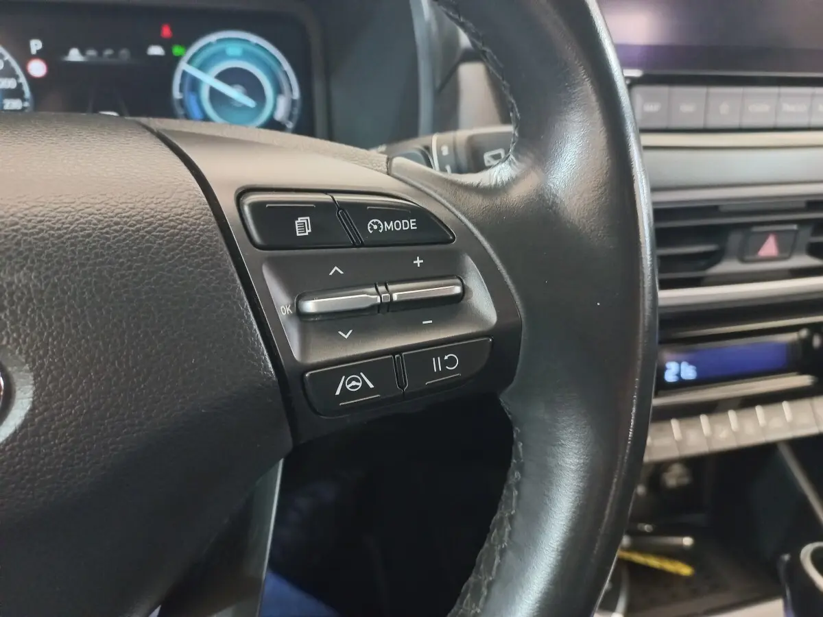 Gros plan sur le volant cuir noir côté gauche du Hyundai Kona 2022 avec commandes multifonctions visibles.