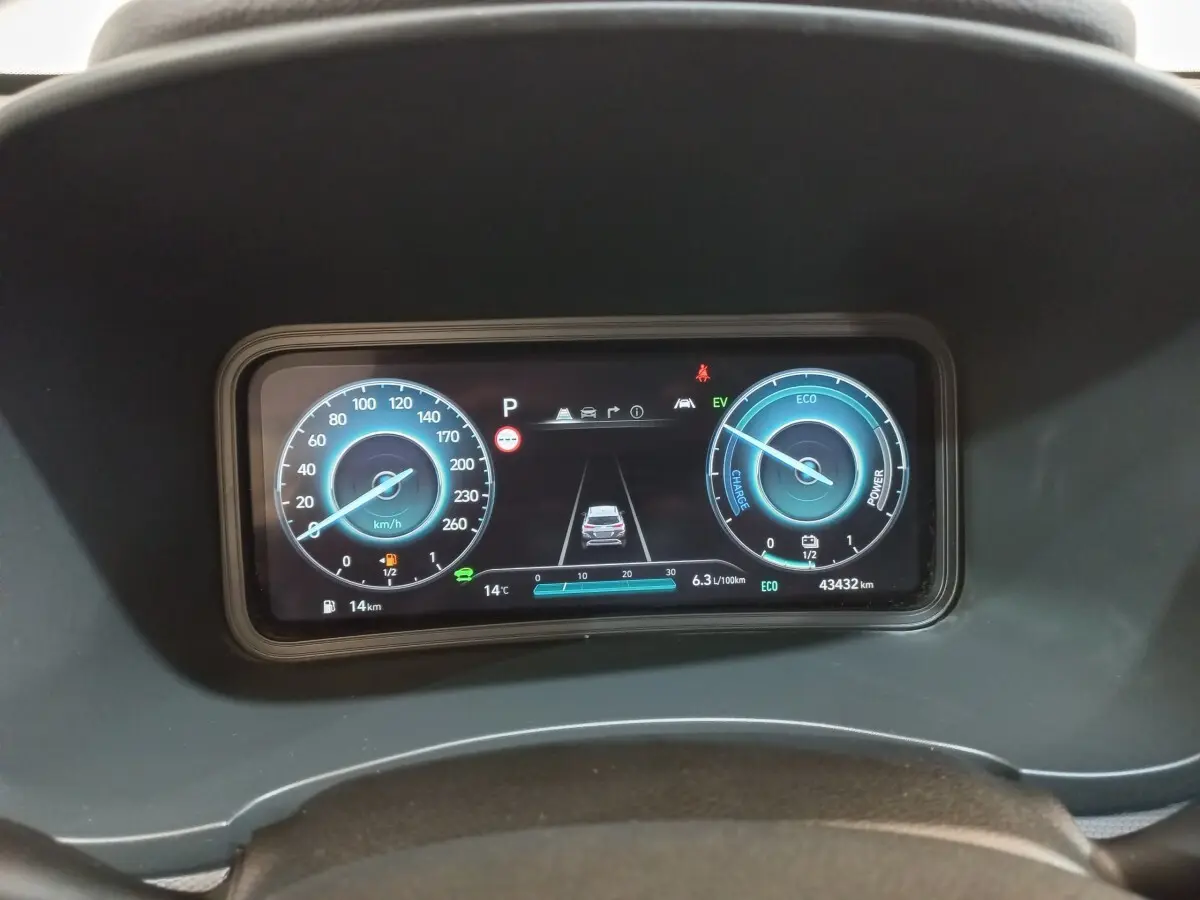 Tableau de bord numérique de la Hyundai Kona 1.6 Hybrid 2022, affichage vitesse et énergie en bleu.