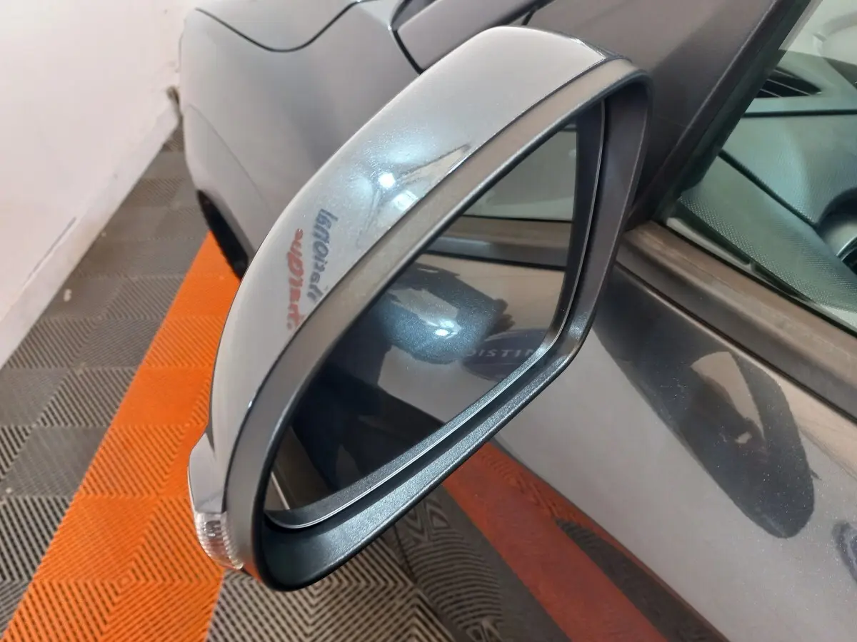 Gros plan sur le rétroviseur côté conducteur gris foncé du Hyundai Kona 1.6 Hybrid 2022, avec clignotant intégré.