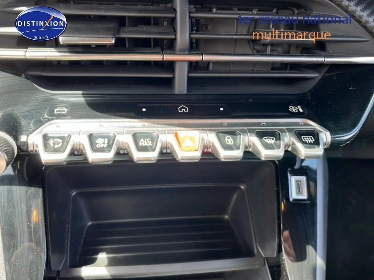 Vue rapprochée sur la console centrale noire du Peugeot 2008 2025, montrant les boutons de commande chromés.