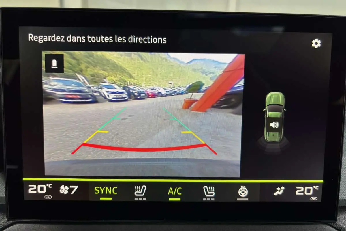 Affichage caméra de recul du Dacia Bigster vert cèdre, vue arrière avec lignes de guidage colorées et capteurs actifs.