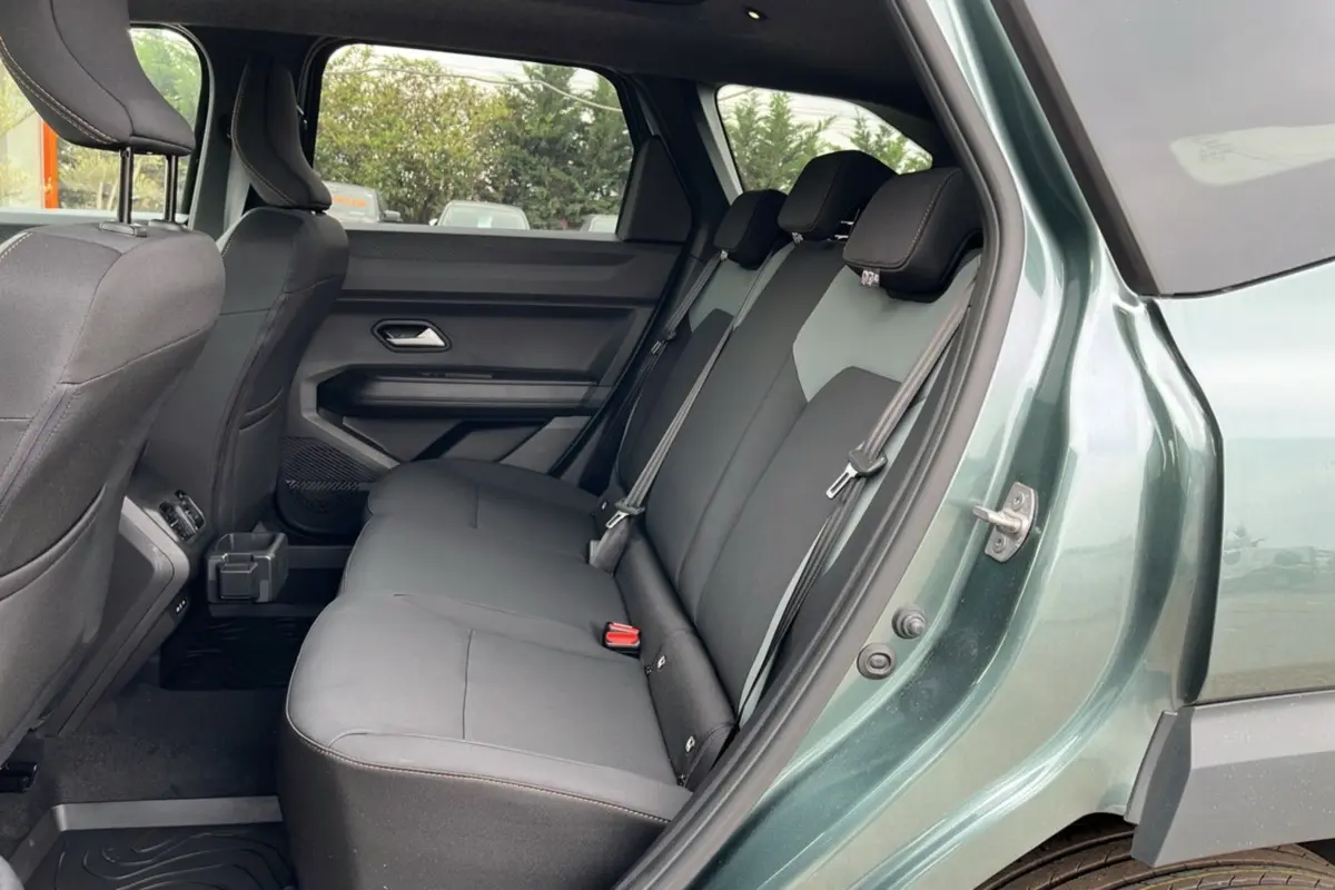 Vue côté gauche de la banquette arrière grise du Dacia Bigster Hybrid 155 Extreme Plus vert cèdre avec ceinture de sécurité.