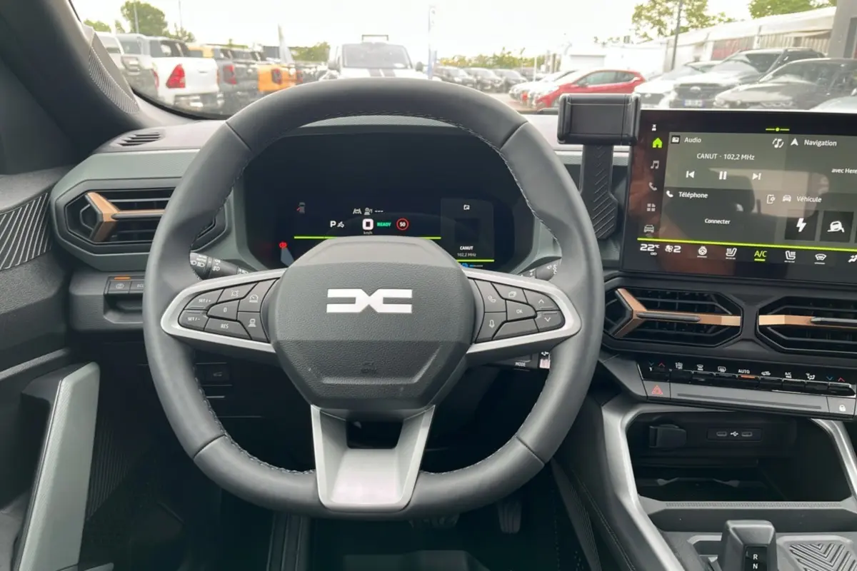 Vue intérieure centrée sur le volant et tableau de bord digital du Dacia Bigster Hybrid 155 Extreme Plus 2025.