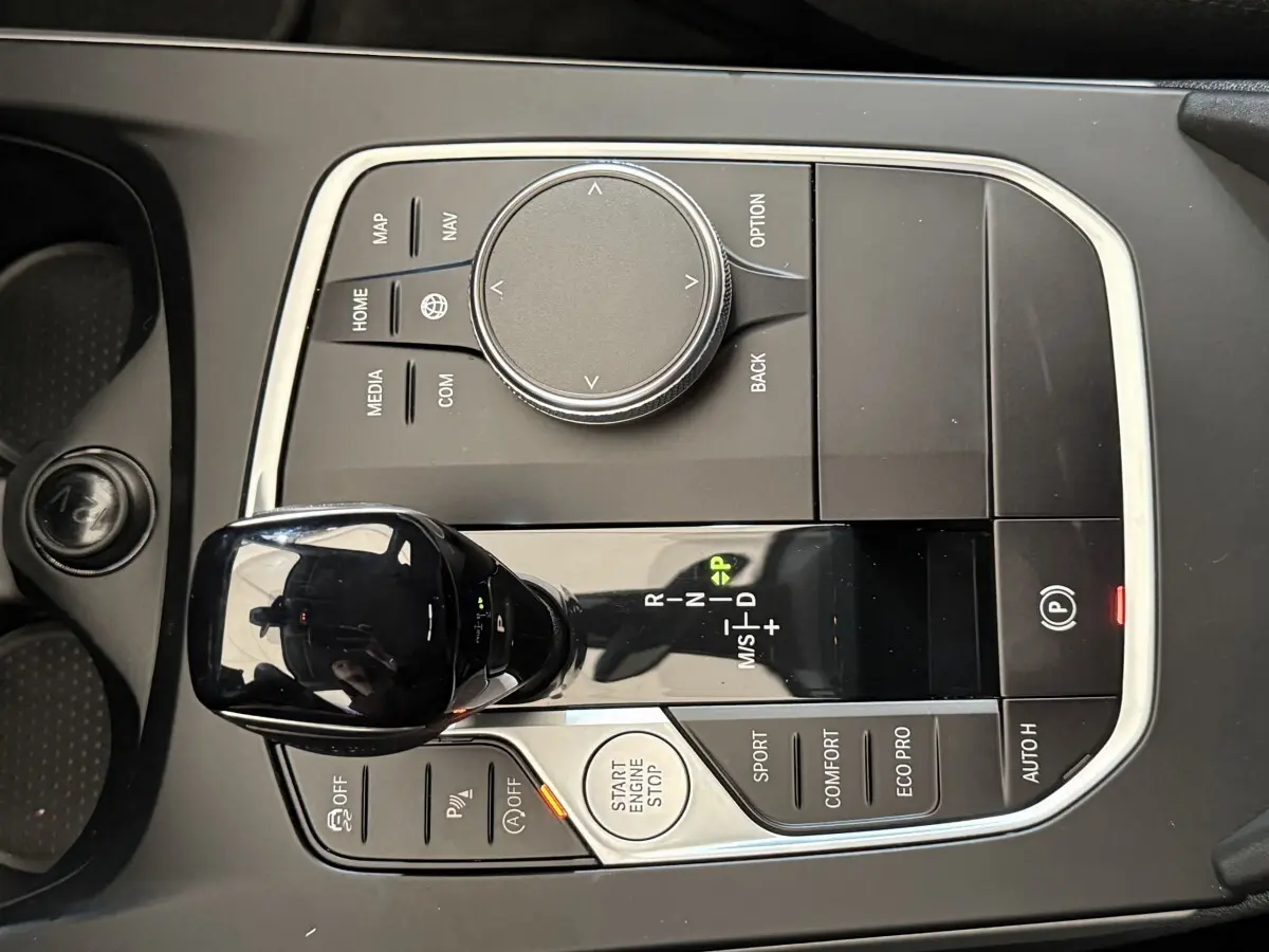 Vue rapprochée de la console centrale noire de la BMW Série 1 116i, avec levier de vitesses automatique et commandes multifonctions.