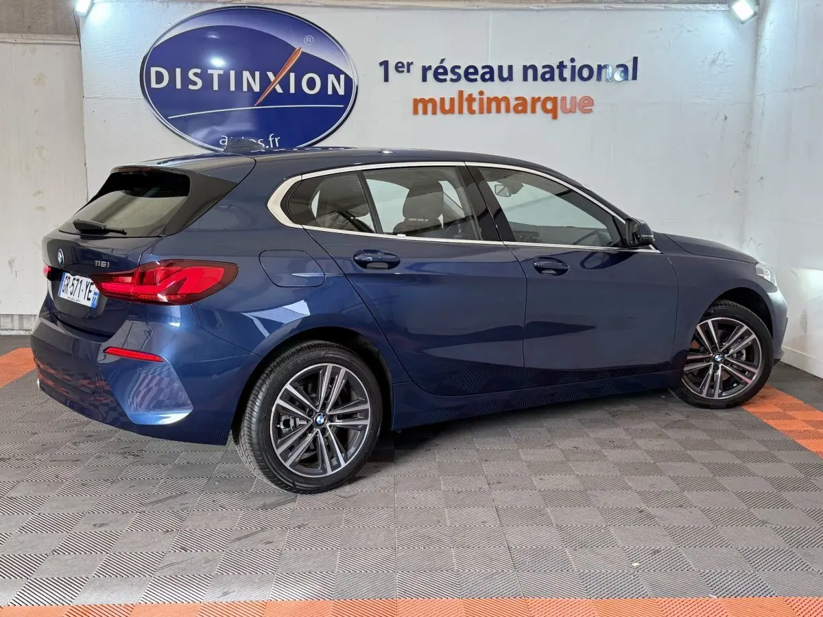 BMW Série 1 116i Business Design bleu vue de profil droit, avec jantes alliage et feux arrière LED distinctifs.