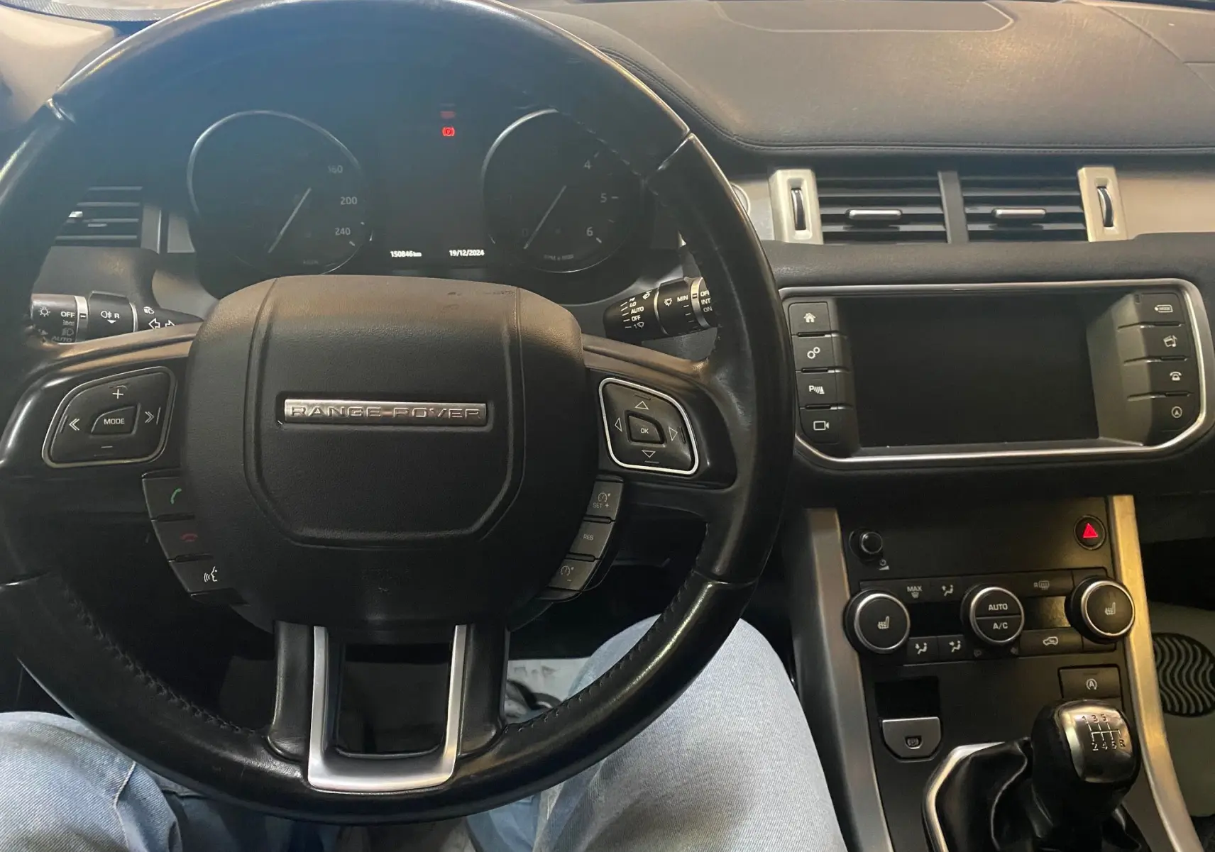 Vue intérieure centrée sur le volant noir du Range Rover Evoque 2016 avec tableau de bord et levier de vitesses manuel visible.