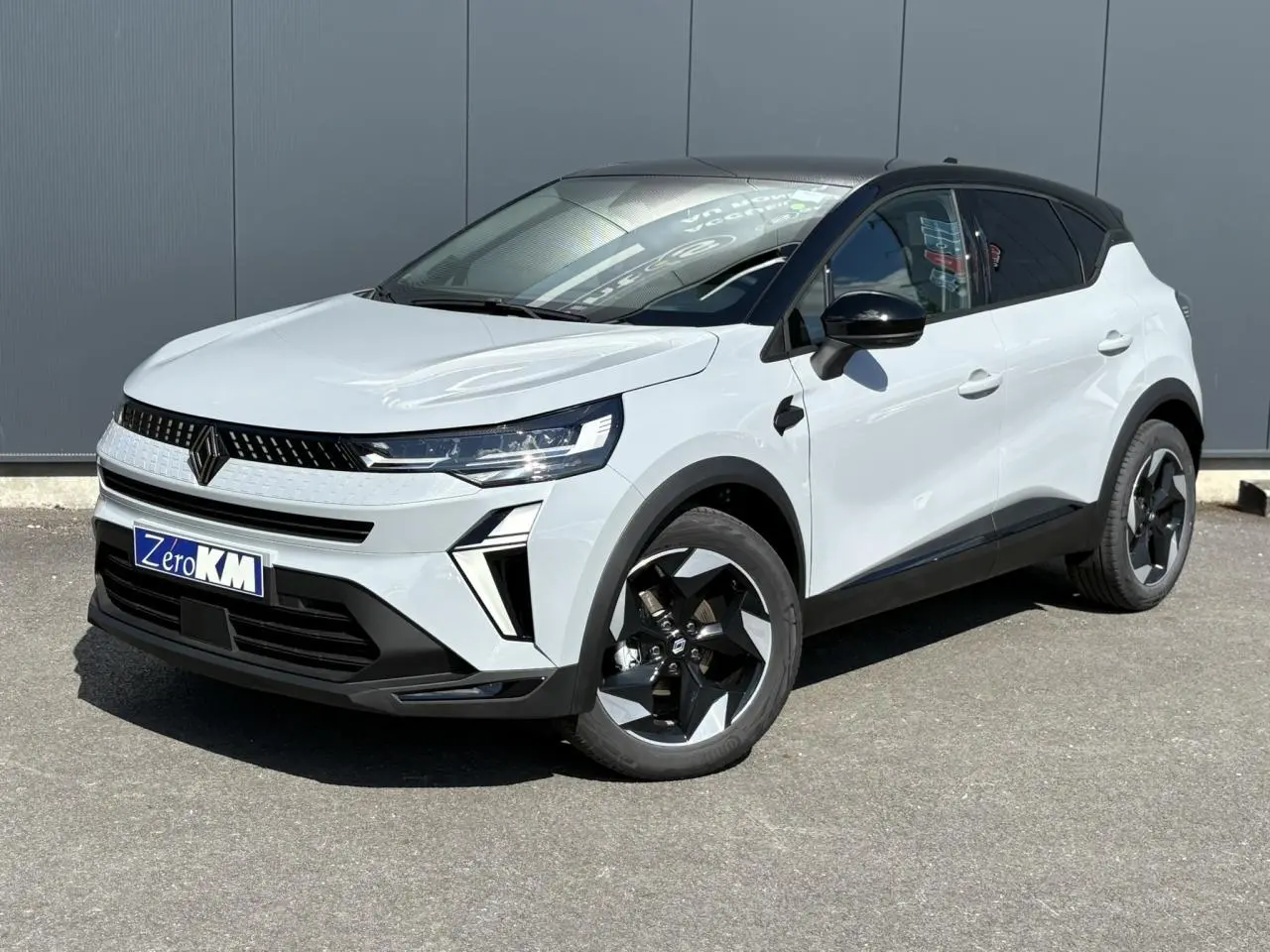 Renault Captur 2025 blanc vue 3/4 avant droit avec toit noir et jantes noires distinctives