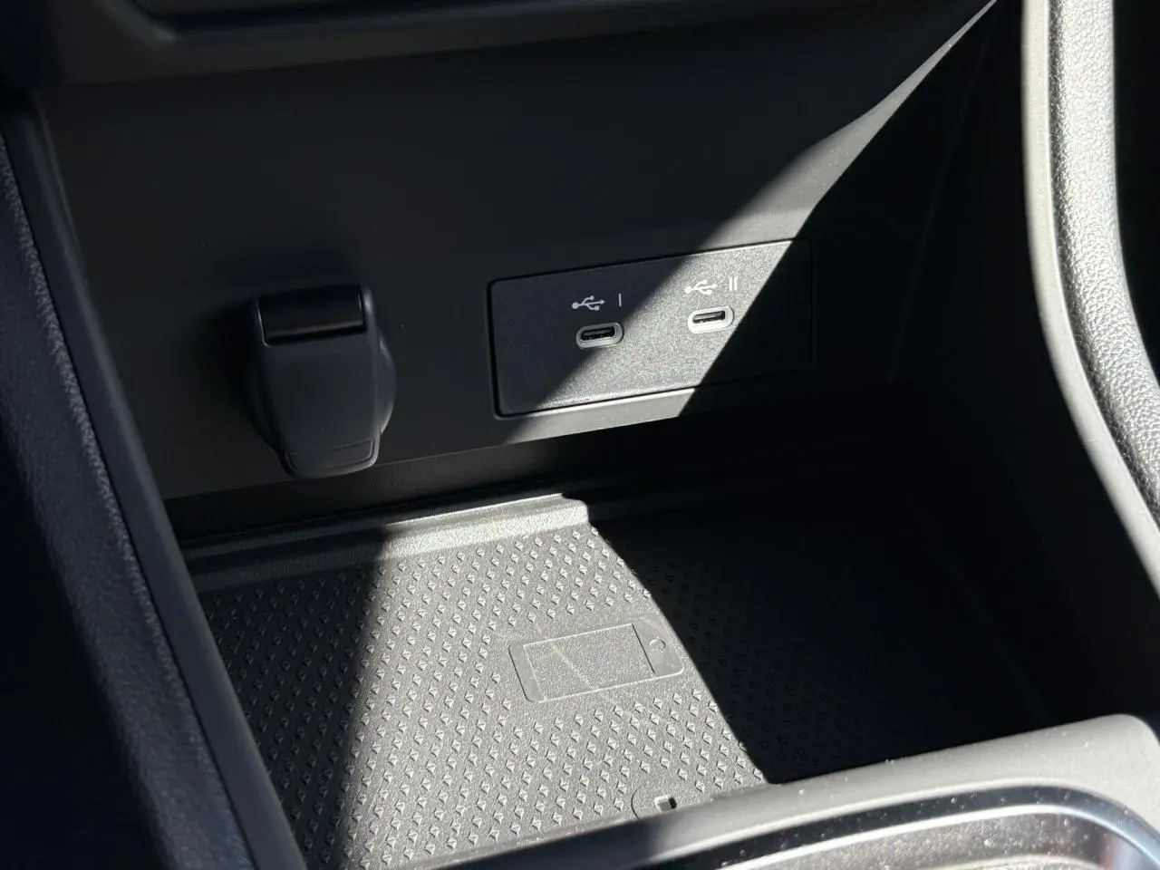 Gros plan sur la console centrale du Renault Captur 2025 avec ports USB-C et zone de charge sans fil noire.