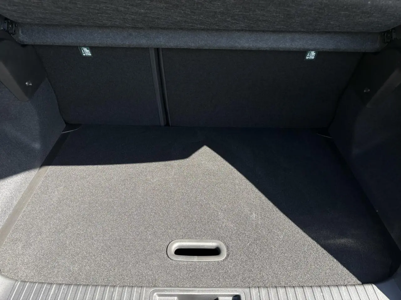 Coffre spacieux du Renault Captur 2025 gris Rafale, vue intérieure sans chargement, plancher mobile visible.