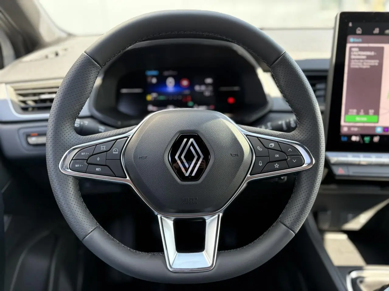 Volant en cuir perforé avec logo Renault, vu de face dans l'habitacle du Renault Captur 2025.
