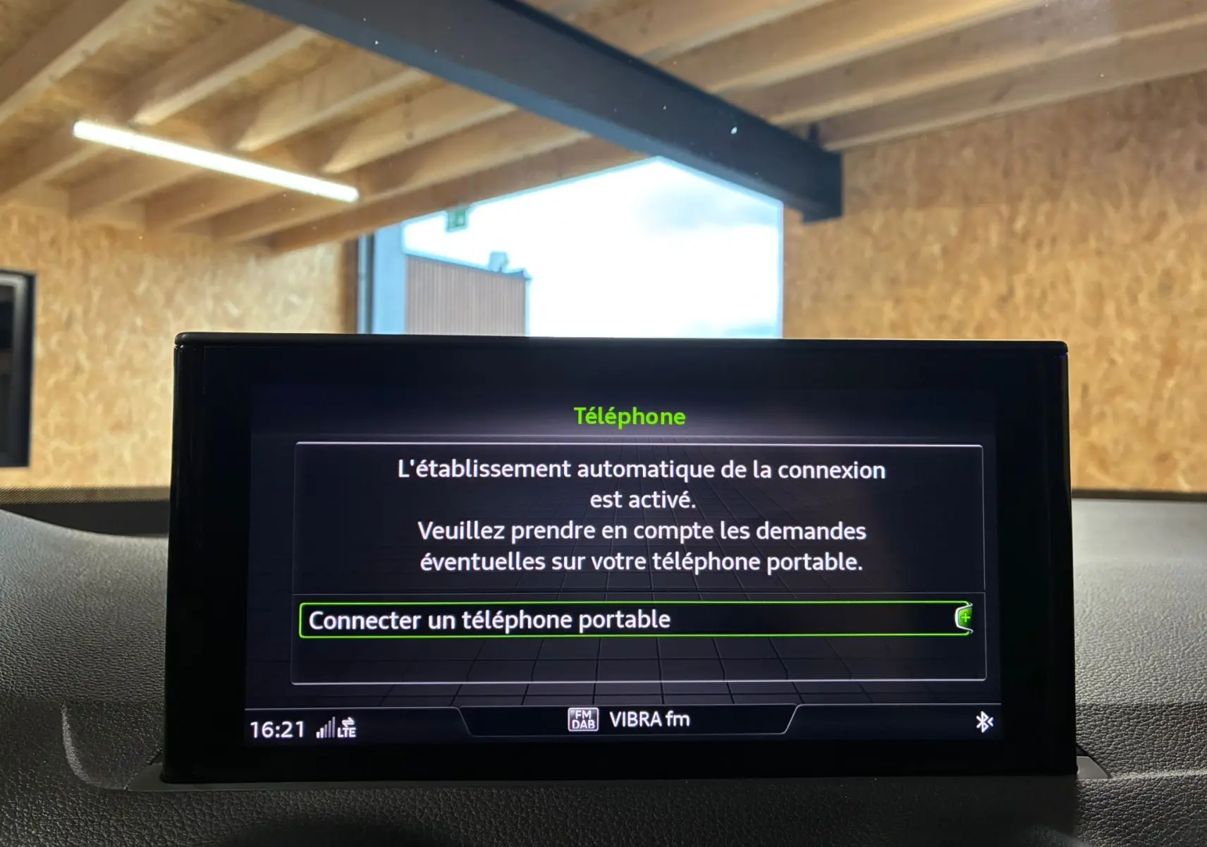Écran central de l'Audi Q2 35 TFSI S-Line 2023 affichant la connexion automatique Bluetooth pour téléphone portable.