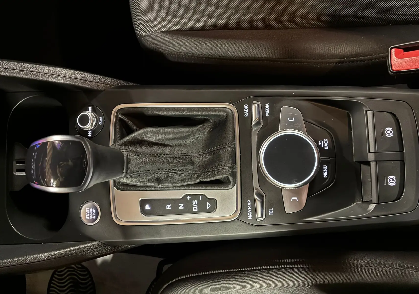 Vue rapprochée de la console centrale noire de l'Audi Q2 35 TFSI S-Line 2023 avec levier de vitesse automatique et commandes multimédia.