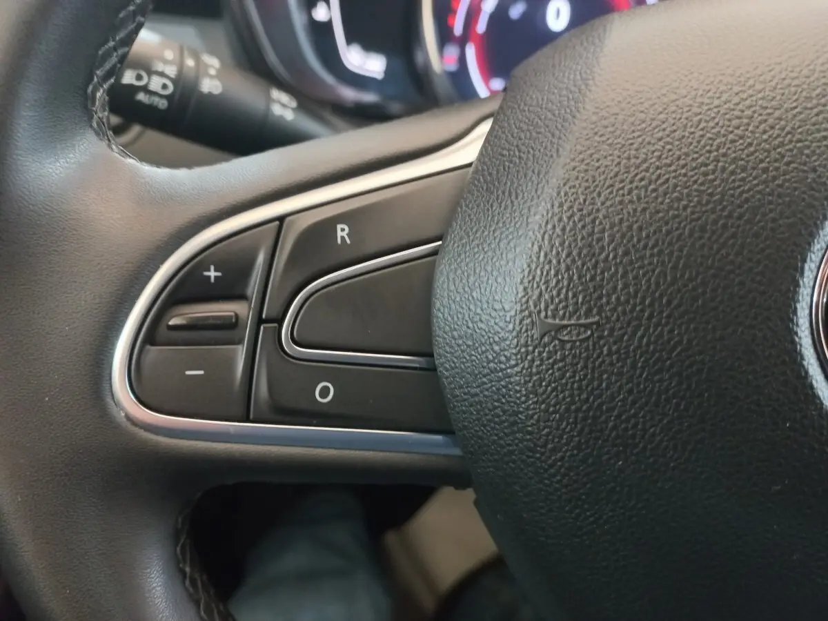 Gros plan sur les commandes de régulateur de vitesse au volant noir du Renault Kadjar Business gris foncé, 2022.