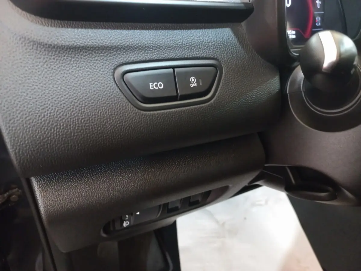 Gros plan sur les commandes ECO et arrêt auto du moteur, côté gauche du tableau de bord noir du Renault Kadjar 2022.