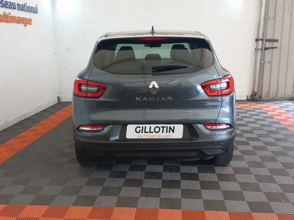 Vue arrière d'un Renault Kadjar gris foncé 2022 dans un garage avec sol à damier gris et orange.