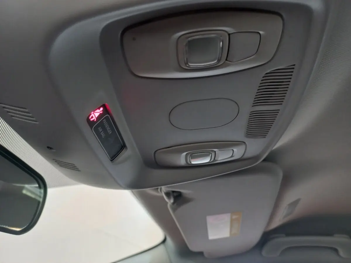 Vue intérieure du plafond avant du Renault Kadjar gris foncé, avec éclairage et témoin airbag passager allumé.