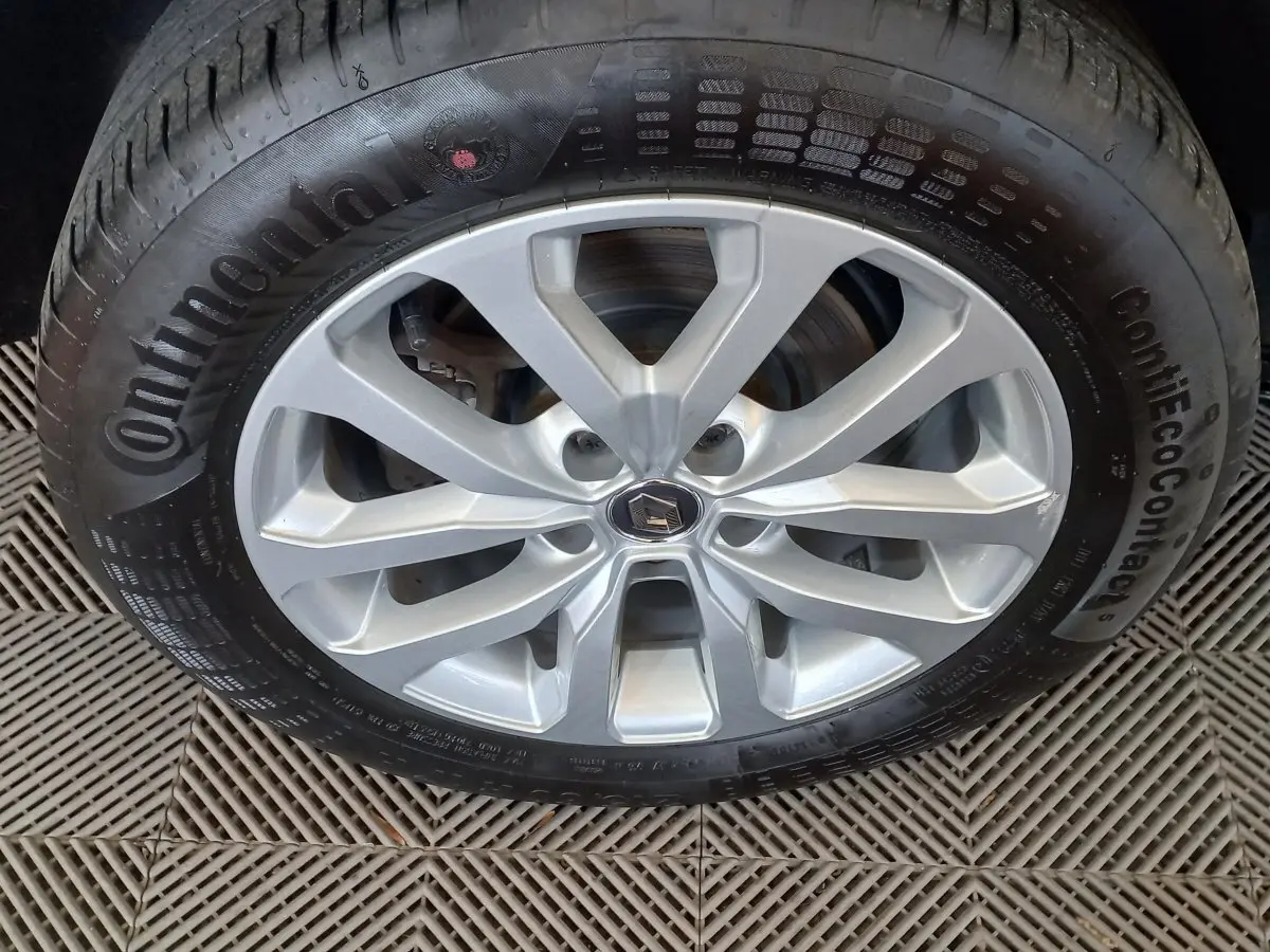 Gros plan sur la roue avant droite du Renault Kadjar gris foncé, jante alliage argentée avec logo Renault central.