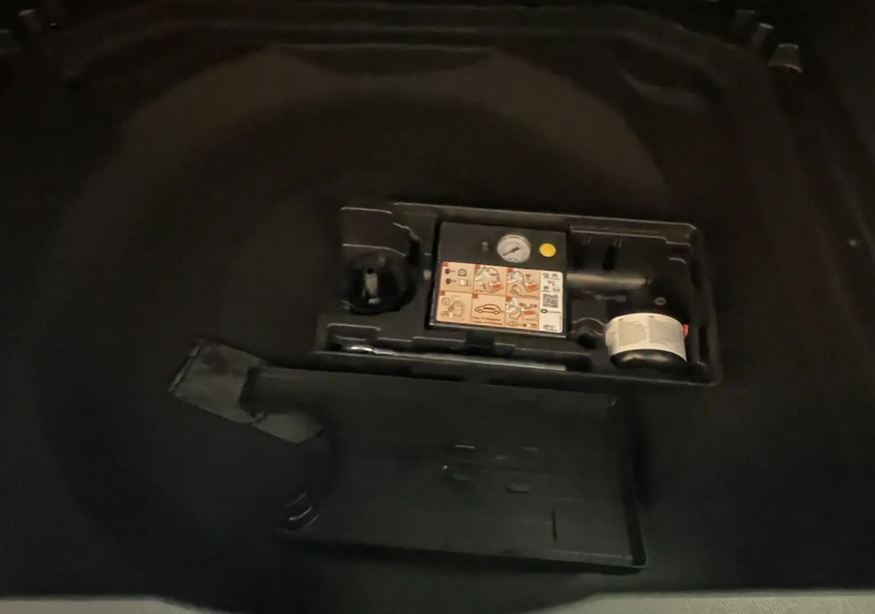 Vue rapprochée du coffre du Citroën C5 Aircross gris platinium, montrant le kit de réparation pneu intégré.