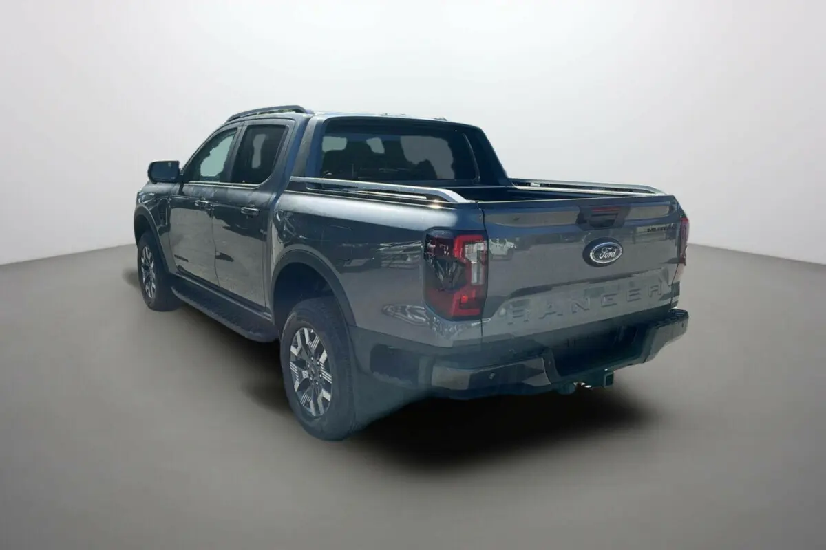 Ford Ranger PHEV gris carbone en 3/4 arrière droit, double cabine avec barres de toit et benne ouverte.
