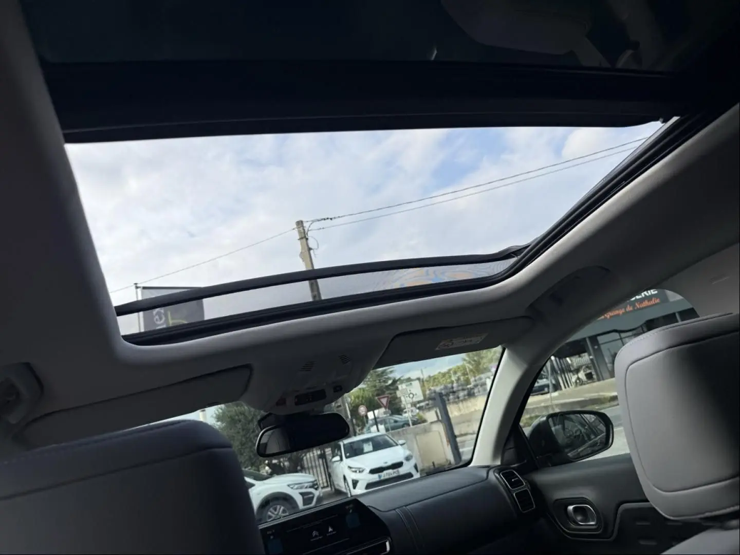 Vue intérieure du toit ouvrant panoramique du Citroën C5 Aircross noir métal 2024, avec ciel visible à travers le verre.