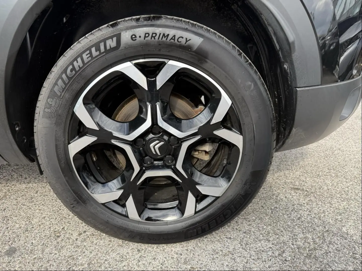 Gros plan sur la roue avant droite du Citroën C5 Aircross 2024 noir métal, jante alliage bicolore et pneu Michelin e-Primacy.