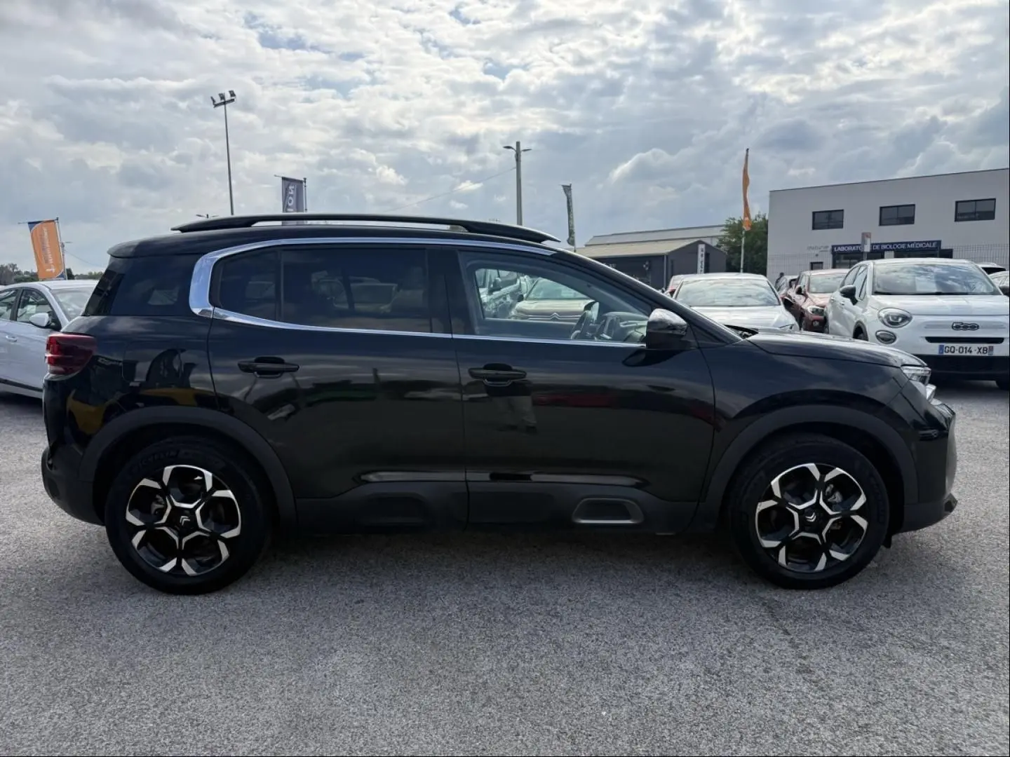 Profil côté droit du Citroën C5 Aircross 1.2 hybride 145 cv noir métal 2024 avec jantes spécifiques et toit ouvrant.