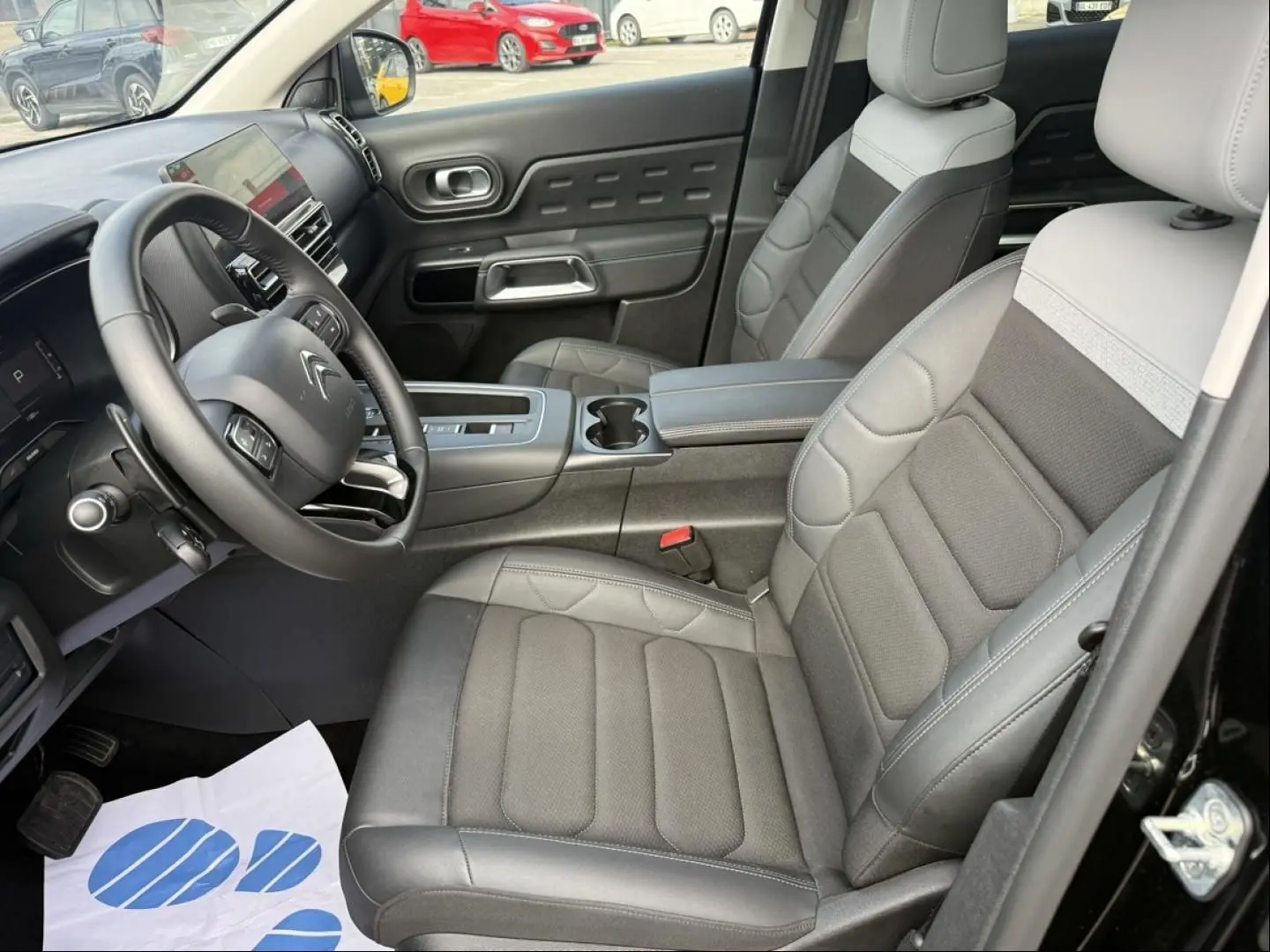 Vue intérieure côté conducteur du Citroën C5 Aircross 2024 noir métal, avec sièges cuir bi-ton et tableau de bord moderne.