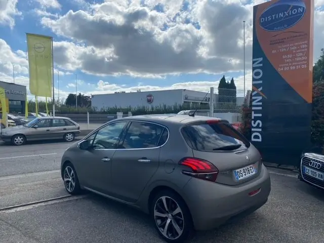 Peugeot 208 gris mat vue 3/4 arrière droit, avec feux arrière distinctifs et jantes alliage modernes.
