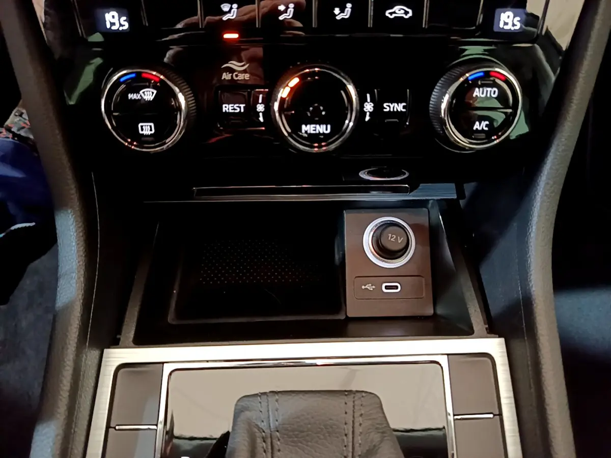 Gros plan sur la console centrale de la Skoda Superb 2020 avec commandes climatisation et prise 12V visible.